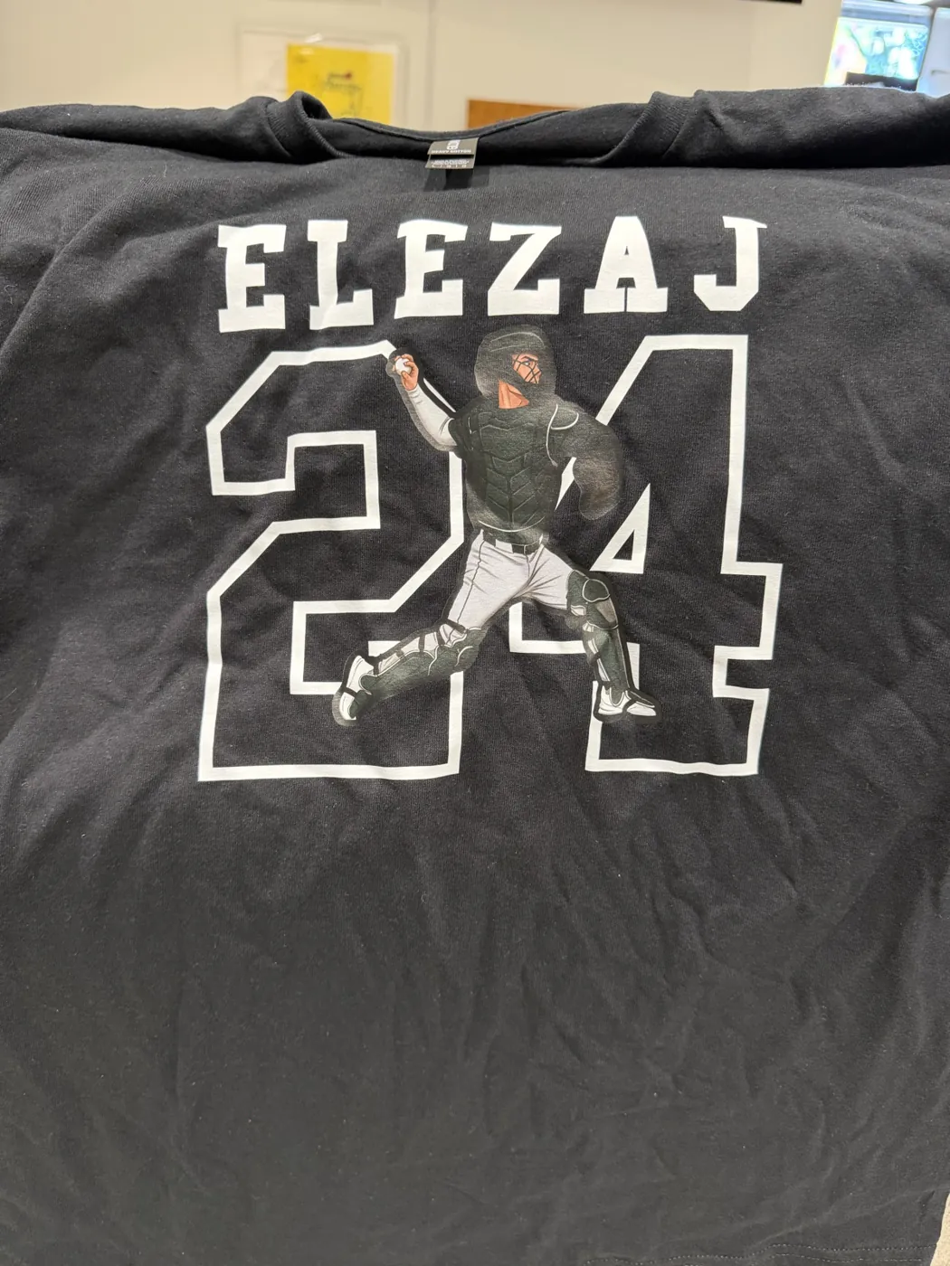 A black Elezaj 24 tee with a catcher design