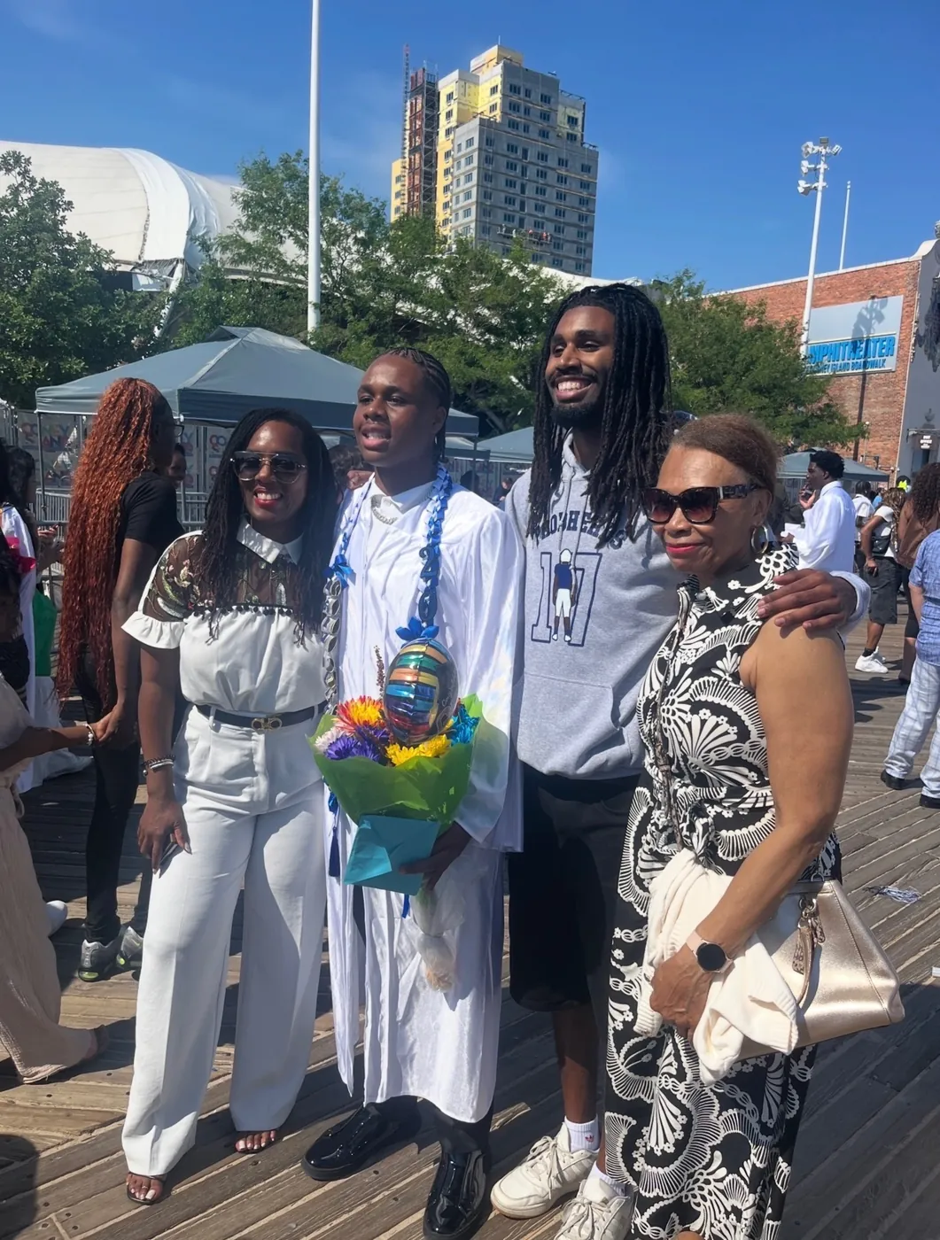 Family at a graduation on a boardwalk, one of them in a grey Probherbs hoodie